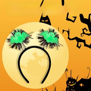 Detail of glow-in-the-dark Halloween headband with green bats and black feather trim