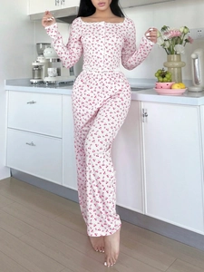 Gros plan sur l'imprimé cerise et dentelle blanche du pyjama deux pièces à fleurs