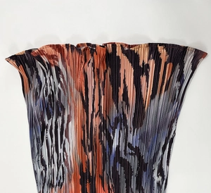 Detailed close-up of high-density vertical pleated fabric with abstract colorful print