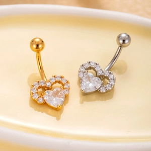 Detailed macro view of heart-shaped belly rings with micro-paved cubic zirconia stones