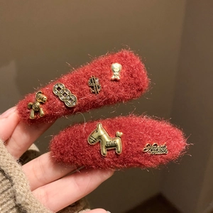 Detail of red plush hair clips with golden lucky horse and Chinese New Year metal ornaments