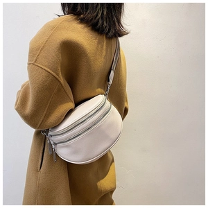 Detail of off-white lychee grain leather crossbody bag with adjustable striped wide strap