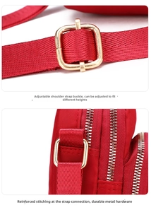 Detail of red nylon crossbody bag with adjustable strap and reinforced golden buckles