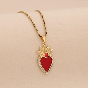 Detail of gold heart pendant with red enamel, crown motif, and sparkling zircons