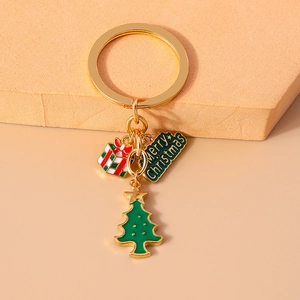 Detailed shot of a gold Christmas keychain with green tree and Merry Christmas pendant