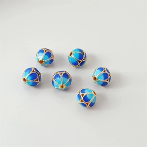 Detailed macro view of six blue cloisonné enamel watermelon beads with gold filigree