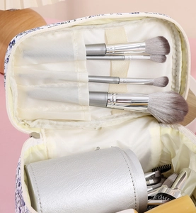 Detailed interior of floral cosmetic bag showing makeup brush slots and main compartment