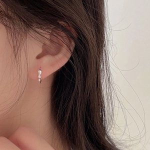 Detail of beaded 925 sterling silver hoop earring on ear with high-polish finish