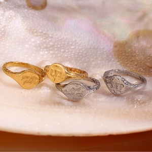 Detail of 18K gold and silver rings with you are gold engraving on seashell background