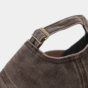 Close-up of vintage washed baseball cap featuring a bronze metal adjustment buckle