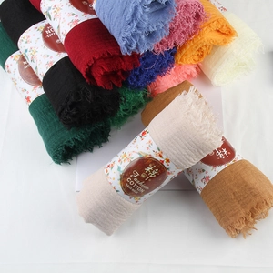 Detail of stacked colorful cotton linen scarves with natural fringe and soft texture