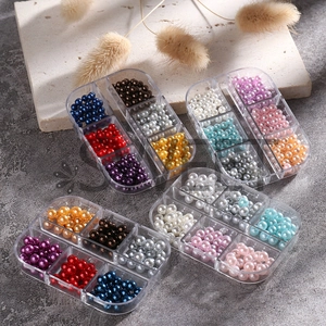 Macro shot of assorted colorful round pearl nail art beads in clear storage box sets
