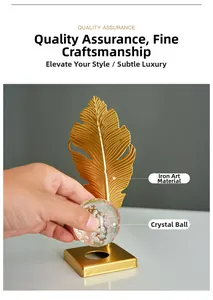 Detail view of golden feather iron sculpture with a crystal ball on a square base