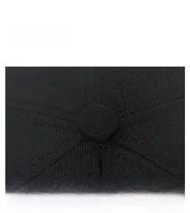 Close-up of top button and twill cotton fabric texture on a black baseball cap