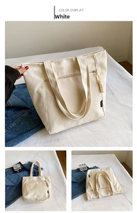 Detail view of a large white canvas tote bag with thick texture and zip pocket