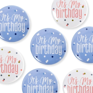 Flat lay of blue and white tinplate birthday badges featuring It's My Birthday text
