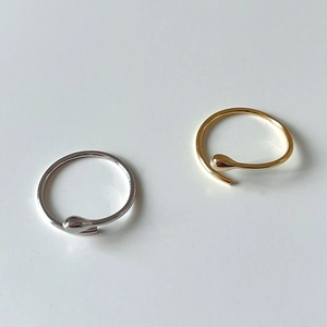 Macro view of gold and silver teardrop open rings with a polished mirror finish