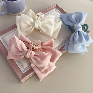 Oversized satin bow hair claws in cream, pink, and blue colors for thick hair