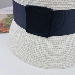 Close-up of white woven straw hat texture with elegant black grosgrain ribbon band