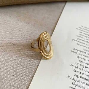 Close-up of golden hollow heart ring on linen background for a minimalist luxury style