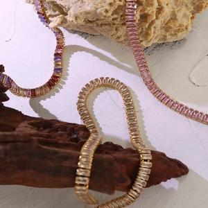 Vintage gold necklace set with colorful zircon stones on natural stones and wood