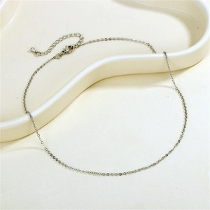 Detail of silver cable chain with lobster clasp and extender on a white wavy tray