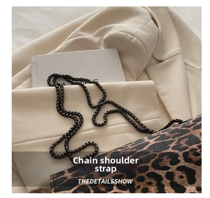 Detail showing metallic square chain strap on leopard print shoulder bag with leather texture
