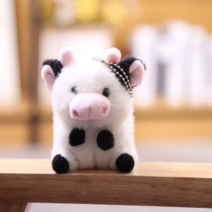 Vista detallada de llavero de peluche de vaca con cadena de bolas y textura suave