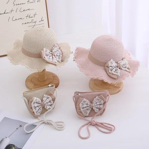 Detail of girls straw sun hat and matching mini purse set with elegant lace bow