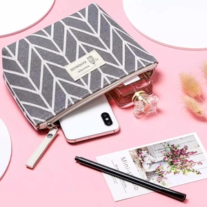 Canvas makeup bag with geometric pattern showing storage for phone and perfume