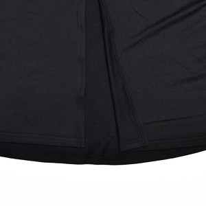Close-up of black polyester dress hem showing high side slit and precise stitching detail