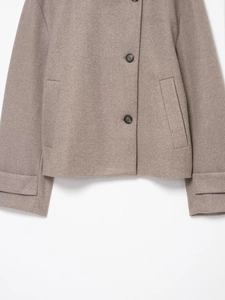 Detailed view of oatmeal wool jacket with dark buttons and refined fabric texture