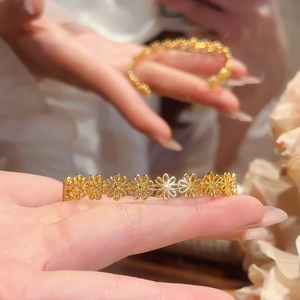 Detailed macro view of golden cutout daisy flower pattern on the elegant bracelet band