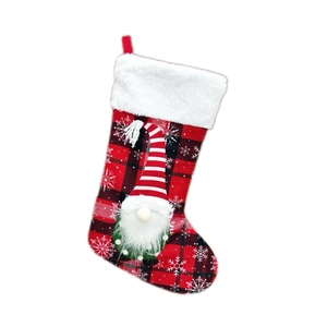 Christmas stocking with red and black plaid pattern featuring a Nordic gnome hanging ornament