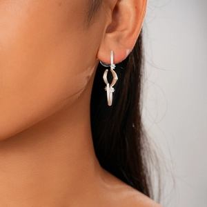Close-up of 18K gold plated silver stud earrings with zircon stars on model's ear