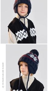 Detailed knit texture of navy blue kids winter hat with Nordic snowflake and pompom