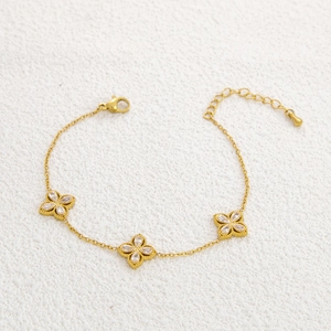 Detailed view of 18k gold plated stainless steel clover bracelet with white zircons