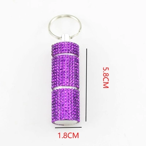 Dettaglio portapillole portachiavi con strass viola, alto 5,8 cm con diametro di 1,8 cm
