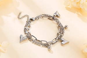Detail view of double-layer silver stainless steel heart and ball pendant bracelet