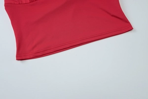 Détail de l'ourlet du haut rouge à col en V montrant la double couture et le tricot