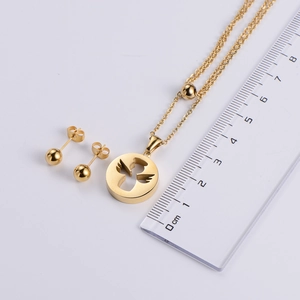 Set di gioielli in acciaio al titanio con orecchini e collana accanto a un righello