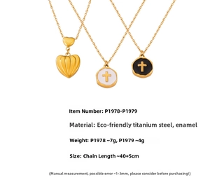 Detailed view of textured heart and cross oil-drop charms on gold titanium necklaces