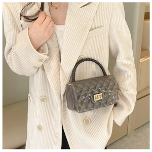 Detail of grey jelly handbag with diamond lattice pattern and black bead handle