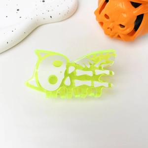 Detailed view of neon green Halloween hair claw clip with skull bone pattern on acrylic