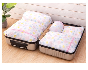 Mesh laundry bags with rabbit prints neatly organized inside a silver travel suitcase