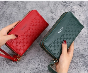 Detailed view of red and green double-zipper long wallets with woven pattern and wrist strap