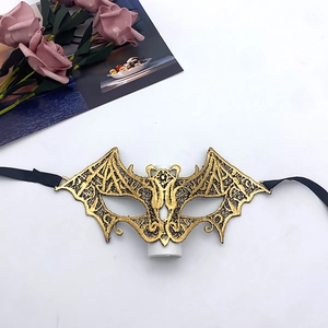Detail of bat-shaped gold and black lace mask with fine embroidery and ribbon ties