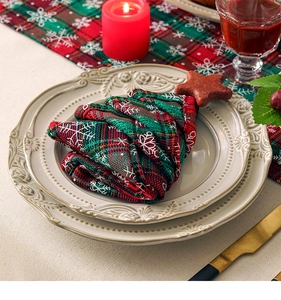 Macro view of Christmas tree-shaped plaid napkin with snowflakes on a ceramic plate