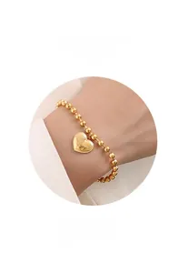 Detail van een 18K vergulde kralenarmband met een hartvormige hanger met letter P