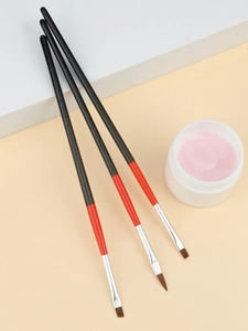 Close-up of professional nail art brushes and pink gel jar on a clean background
